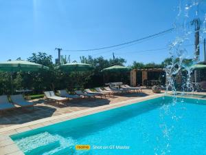 a swimming pool with chairs and a fountain at Casolare Lodedo in Ceglie Messapica