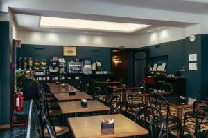 a restaurant with wooden tables and chairs and a bar at Hotel Italia in Turin