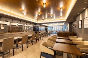 a dining room with wooden tables and chairs at KOKO HOTEL Sapporo Susukino 2ⁿᵈ in Sapporo