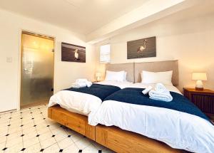 a bedroom with a large bed with towels on it at Brückendorf 11 Self-catering townhouse in Swakopmund