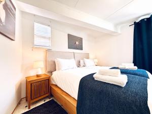 a bedroom with a bed and a night stand at Brückendorf 11 Self-catering townhouse in Swakopmund