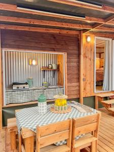 a dining room with a table and chairs in a cabin at Camping Magali Plage in Liourdres