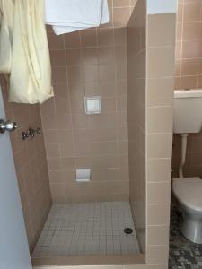 a bathroom with a shower with a toilet at Ettalong Beach motel in Ettalong Beach +32 photos