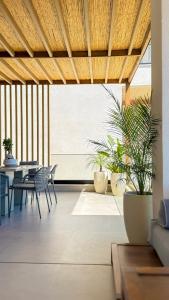 a living room with a table and chairs and plants at Villa 4 - Drymades - Thymus Residence in Dhërmi