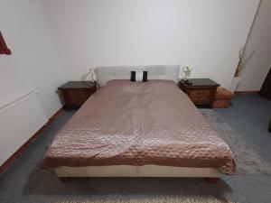 a large bed in a room with two tables at Izba v centre in Bardejov