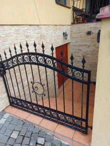 a black iron fence with a door in a building at Izba v centre in Bardejov