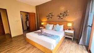 a bedroom with a large white bed with a wooden headboard at Blue Planet Panglao in Panglao Island