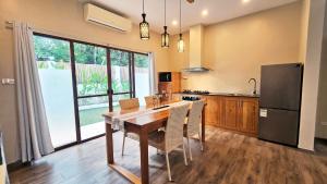 a kitchen with a wooden table and a refrigerator at Blue Planet Panglao in Panglao Island +68 photos