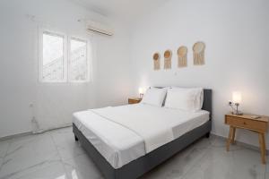 a white bedroom with a bed and a window at Nerea Eleon Residences in Eleonas +24 photos