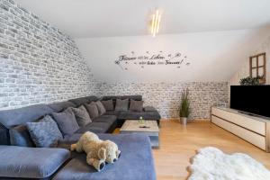 a living room with a brown teddy bear laying on a couch at Fewowe Ferienwohnung Wenden in Wenden