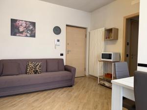 a living room with a couch and a tv at Dimora del Centro in Acqui Terme