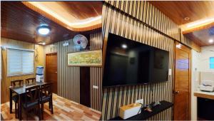 a room with a large television on a wooden wall at JMCL RESIDENCES in Tacloban