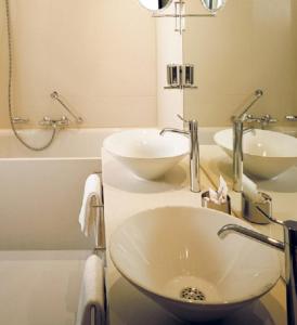 a bathroom with two sinks and a mirror at Kult Hotel in Ingolstadt +28 photos