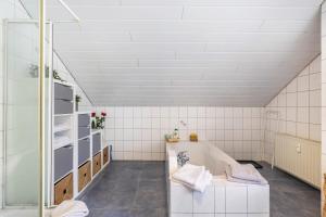 a bathroom with a tub and a shower at Fewowe Ferienwohnung Wenden in Wenden +24 photos