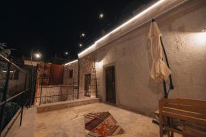 a patio with an umbrella on a wall at night at Velum Cappadocia in Göreme