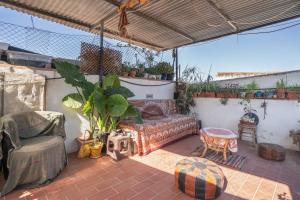 a patio with a couch and a table and a chair at Casa Pantha in Vélez-Málaga