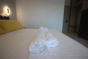 a bed with towels on top of it at Avli Rooms in Himare +233 photos