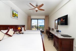 a hotel room with two beds and a balcony at Praha Hotel Phú Quốc in Phú Quốc