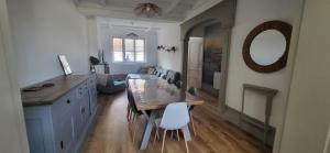 a kitchen with a dining table and a living room at Le Cocon des Sables in Sangatte