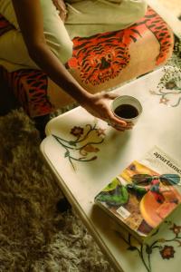 a woman painting a table with a book on it at MONKEY RESORT in McLeod Ganj