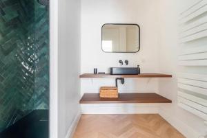 a bathroom with a sink and a mirror at House Moringa Rituals Pool in Le Plessis-Trévise +9 photos