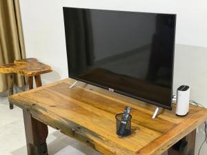 a large flat screen tv sitting on a wooden table at 2BR Apartment in Tanga in Tanga