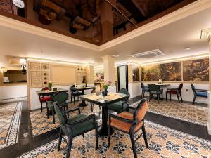 a restaurant with tables and chairs and paintings on the walls at Eliana Robusta Hotel in Hanoi