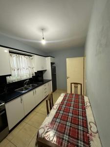 a kitchen with white cabinets and a table and chairs at Aparthotel Borsh in Borsh