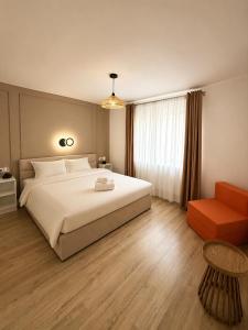 a bedroom with a large white bed and a chair at Stai Ca Acasă in Slănic-Moldova