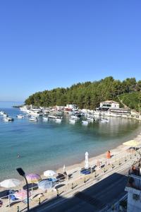 a beach with umbrellas and boats in the water at Ionian Balcony in Himare