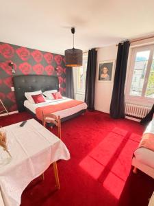 a bedroom with a bed and a red carpet at Hotel De Paris in Poligny +15 photos