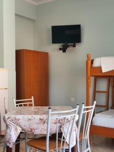 a dining room table with chairs and a tv on a wall at Ionian Balcony in Himare