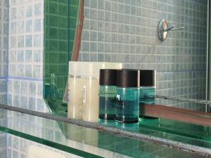 a glass shelf with some bottles on it in a bathroom at Ionian Balcony in Himare
