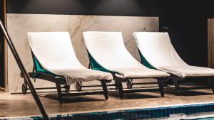 a row of chairs sitting next to a swimming pool at Jacob Sea Life Nahariya in Nahariyya