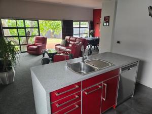 a kitchen with a sink and a living room at De Vine Martinborough #14a in Martinborough