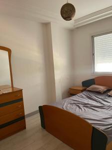 a bedroom with a bed and a dresser and a window at S1 hammamet mrezga in Nabeul
