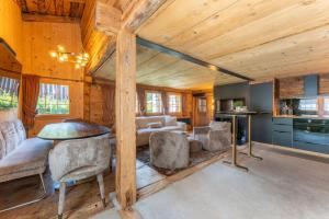 ein Wohnzimmer mit Holzdecke, Tisch und Stühlen in der Unterkunft Heidi's Hideout - Private historic chalet by Heiti Gstaad in Gstaad