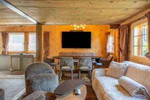 ein Wohnzimmer mit Sofa und Tisch in der Unterkunft Heidi's Hideout - Private historic chalet by Heiti Gstaad in Gstaad