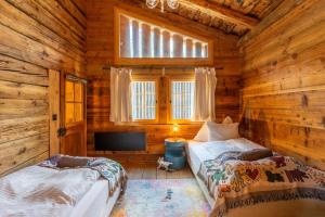 ein Schlafzimmer mit zwei Betten in einer Blockhütte in der Unterkunft Heidi's Hideout - Private historic chalet by Heiti Gstaad in Gstaad