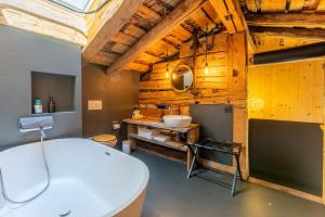 ein Badezimmer mit einer weißen Badewanne und einem Waschbecken in der Unterkunft Heidi's Hideout - Private historic chalet by Heiti Gstaad in Gstaad + 62 Fotos