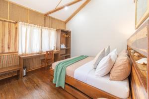 a bedroom with a bed and a desk at Camanolo Residence in General Luna