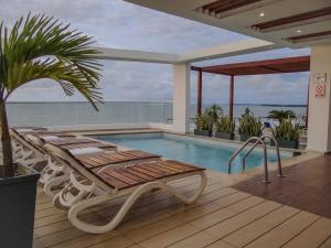 a swimming pool with a chaise lounge next to a swimming pool at Hotel Summer Frente Al Mar in Cartagena de Indias