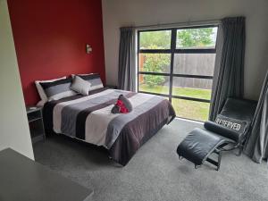 a bedroom with a bed with a teddy bear on it at De Vine Martinborough #14a in Martinborough