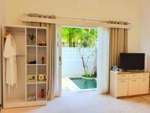 a living room with a door open to a pool at Harmony Villas in Kuta Lombok