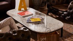 a marble coffee table in a living room with books on it at Jacob Shenkin Hotel in Tel Aviv