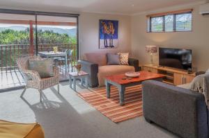 a living room with a couch and a table and a television at Mountainview Sedgefield in Sedgefield