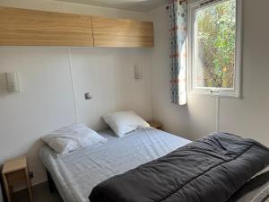 a bedroom with a bed and a window at Camping De Collignon in Cherbourg en Cotentin +132 photos