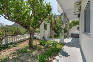 a house with a tree and a sidewalk at 30Roses House in Sálakos