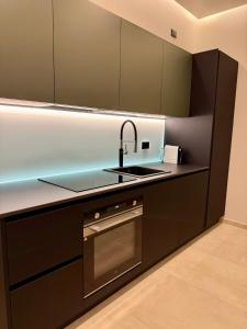 a kitchen with a sink and a stove at H Luxury Apartment Crispi in Olbia