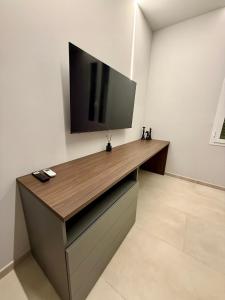 a flat screen tv on a wall in a room at H Luxury Apartment Crispi in Olbia